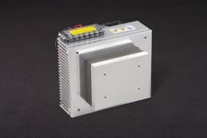 Three-quarter view of thermoelectric cold plate cooler/heater. Cooled aluminum plate on the front, waste heat is exhausted to fins on back. Fins are fan cooled. The fan air enters on the middle back and exhausts on sides. Operates on 12 volts DC and removes 32 watts of heat at a 0°C temperature difference relative to ambient. An internal extender block improves the heat pumping capacity at larger temperature differences. Can heat to 100°C without damaging the cooler.